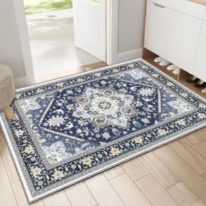 Blaue Fußmatte mit orientalischem Medaillonmuster und Bordüre vor einer geöffneten Tür