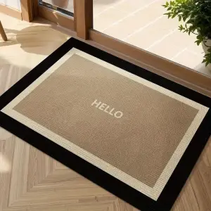 Beige Fußmatte mit schwarzem Rand und kleinem Schriftzug „Hello“ vor einer Holztür